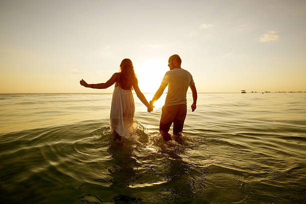 istock Romantic couple on the beach at colorful sunset on background 545589938