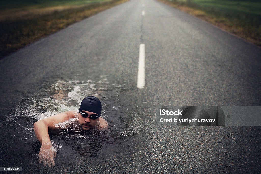 Strong Man Swim On Asphalt Road Bizarre Stock Photo