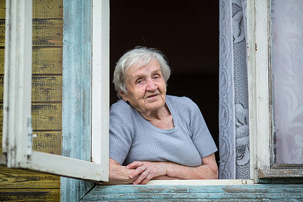 istock An elderly woman looks out from the window 545591620