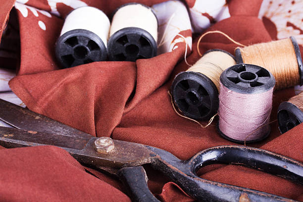 istock Scissors and cotton for sewing on brown material 545594306
