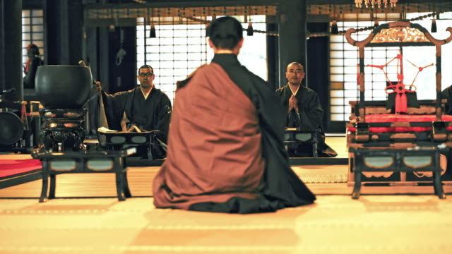 DS Japanese monks praying in a temple
