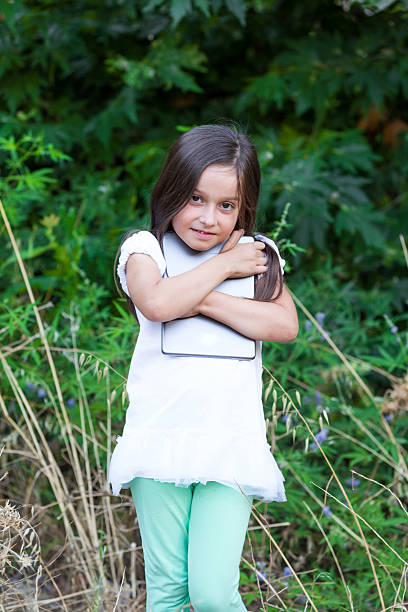 istock little girl playing in the woods with digital tablet 545636710