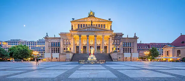 Panoramic view of famous Gendarmenmarkt square with Berlin Concert Hall in twilight during blue hour at dusk, Berlin Mitte district, Germany.