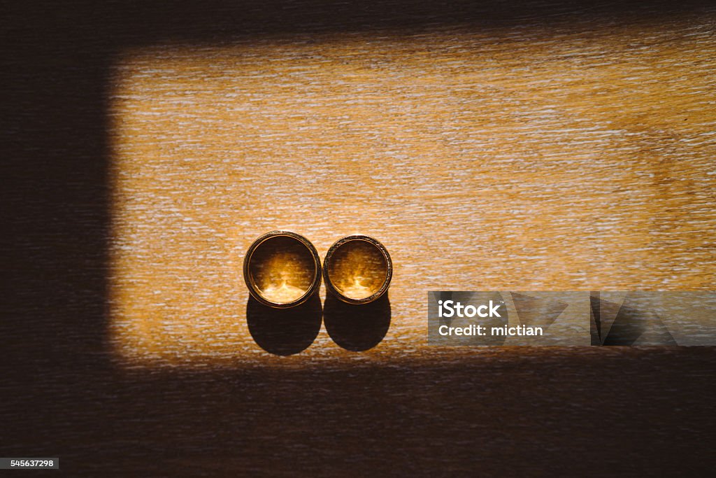 wedding rings on wooden background in sunlight Anniversary Stock Photo