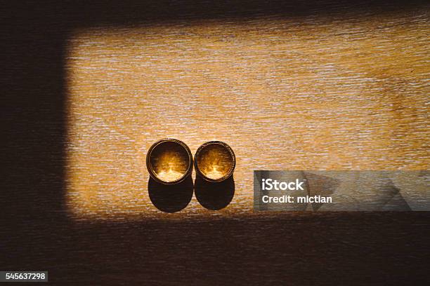 Wedding Rings On Wooden Background In Sunlight Stock Photo - Download Image Now - Anniversary, Arrangement, Beauty