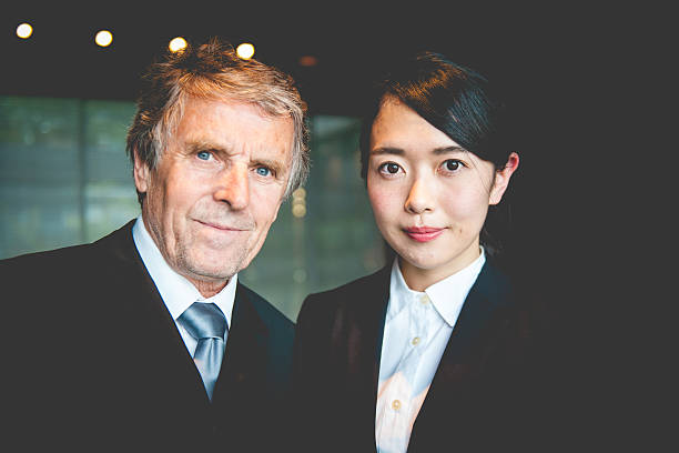 empresário caucasiano sênior e mulher empreendedora japonesa, kyoto, japão - senior men businessman portrait dark - fotografias e filmes do acervo