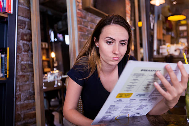 Beautiful young woman looking at menu