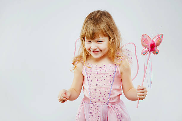belle petite fille posant avec un bâton magique en studio - fairy costume photos et images de collection