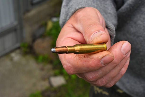 istock Man hand showing 7.62 caliber ammunition bullet 545640898