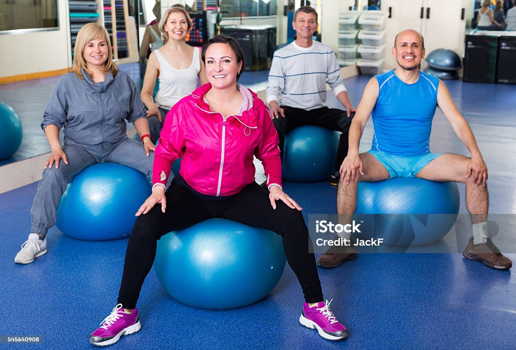 Adults doing aerobics with balls Group of adults doing aerobics with balls in a sport club 40-44 Years Stock Photo