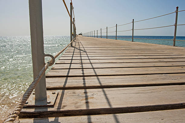 istock Wooden pier from beach on tropical sea 545647118