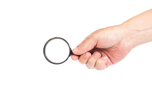 istock Hand holding magnifying glass isolated on white background 545649072