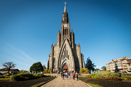 Canela, Rio Grande do Sul - Brazil - June 29, 2016: View of the Cathedral of Our Lady of Lourdes (Portuguese: Catedral Nossa Senhora de Lourdes), along with people, buildings and nature in the heart of Canela city, Rio Grande do Sul state - Brazil