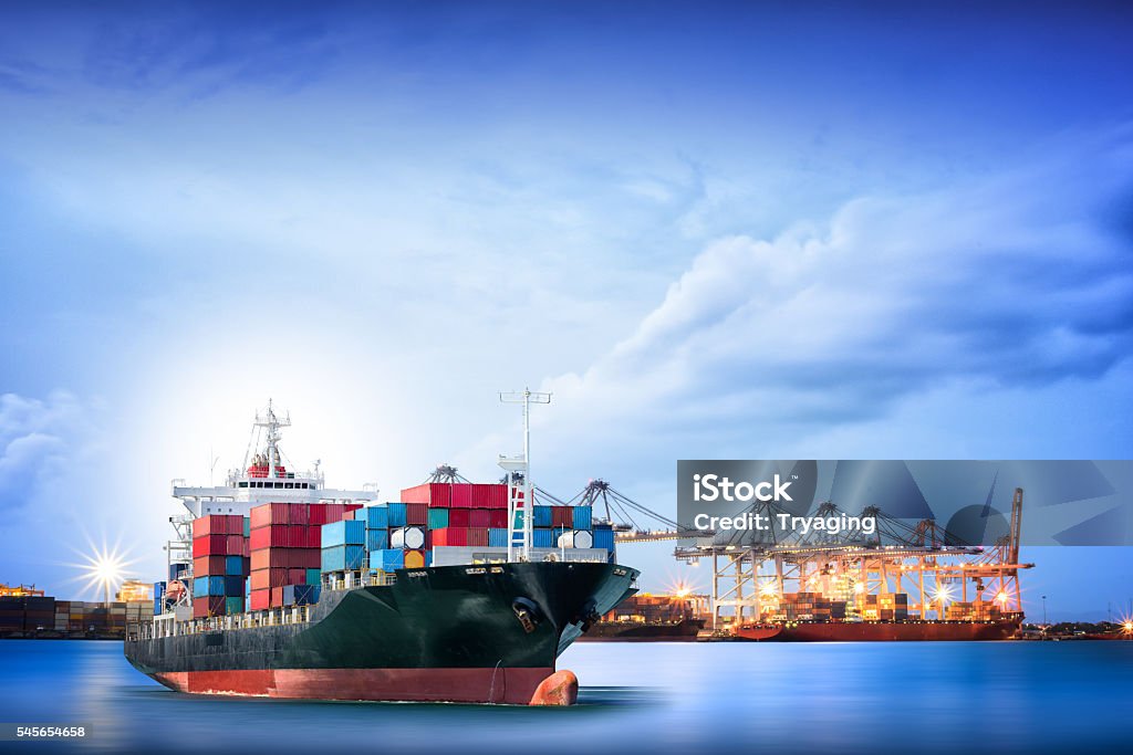 Logistics and transportation of International Container Cargo ship Logistics and transportation of International Container Cargo ship with ports crane bridge in harbor for logistic import export background and transport industry. Freight Transportation Stock Photo