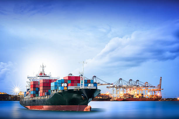 Logistics and transportation of International Container Cargo ship Logistics and transportation of International Container Cargo ship with ports crane bridge in harbor for logistic import export background and transport industry. military ship photos stock pictures, royalty-free photos & images
