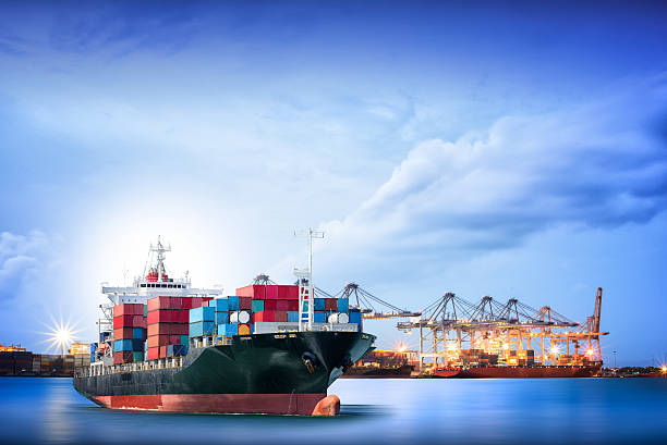 Logistics and transportation of International Container Cargo ship Logistics and transportation of International Container Cargo ship with ports crane bridge in harbor for logistic import export background and transport industry. maritime container stock pictures, royalty-free photos & images