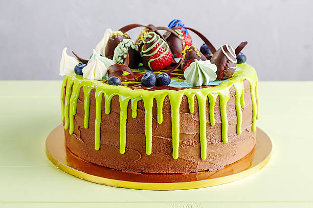 istock Chocolate birthday cake with fruit and green glaze 545655028