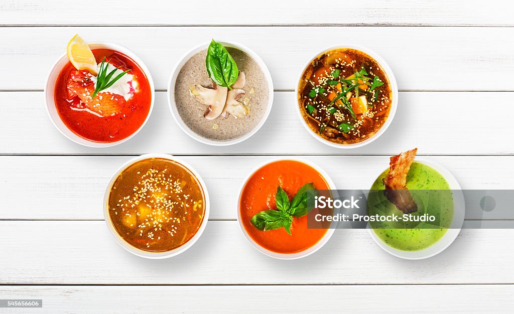 Variety of soups at white wood, top view Variety of restaurant hot dishes, healthy food. Japanese miso soup, asian fish soup, russian borscht, english pea soup with bacon, mushroom soup, spanish gazpacho at white wood, top view Soup Stock Photo