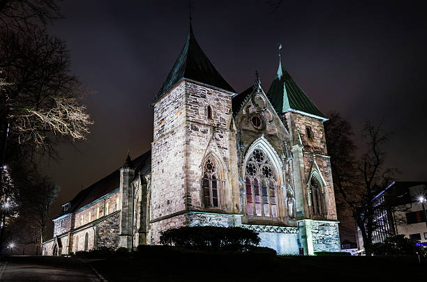 catedral stavanger domkirke à noite bem iluminada. paisagem gótica escura da cidade. - church gothic style cathedral dark - fotografias e filmes do acervo