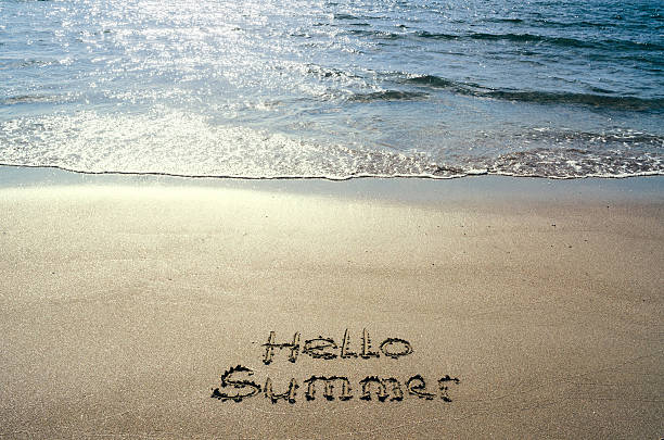 istock Hello summer handwritten on beach sand. Water sea background. 545656964