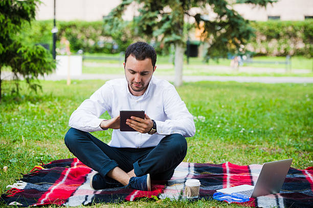 istock young businessman at the park working with tablet 545657902