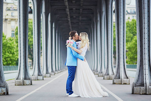 Just married couple in Paris, France Just married couple in Paris, France. Beautiful young bride and groom on Bir-Hakeim bridge. Romantic wedding concept eloping stock pictures, royalty-free photos & images