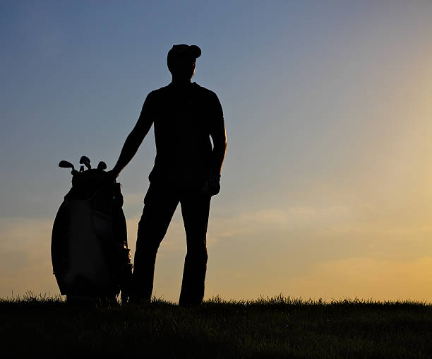 Male golfer playing golf at sunset
