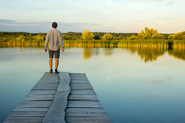 istock Alone man standing on the edge of a pier 545661002