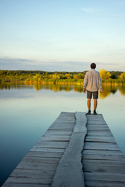 istock Alone man standing on the edge of a pier 545661144