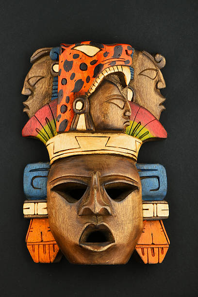 Indian Mayan Aztec wooden carved painted mask isolated on black Indian Mayan Aztec wooden carved painted mask with roaring jaguar and human faces isolated on black paper background aztec civilization photos stock pictures, royalty-free photos & images