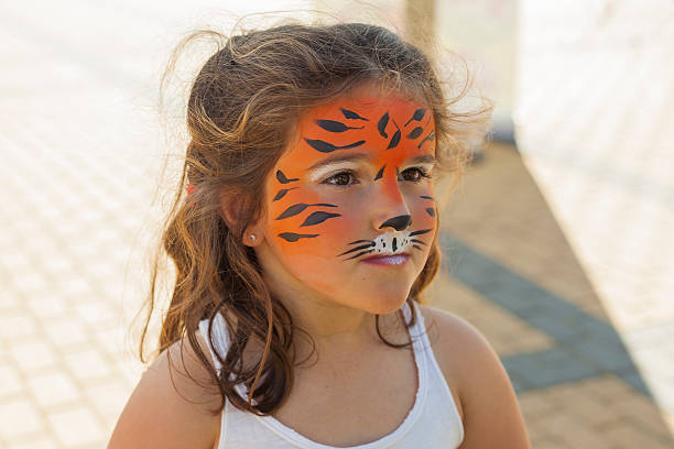 menina com o rosto pintado como um tigre - applying make up - fotografias e filmes do acervo