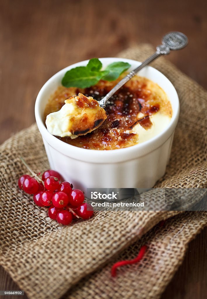 Creme brulee (burnt cream) Creme brulee (cream brulee, burnt cream) with red currant and mint Baked Stock Photo