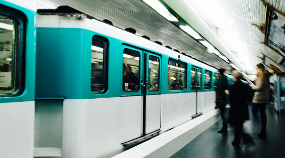 People boarding train at subway metro station in Paris.