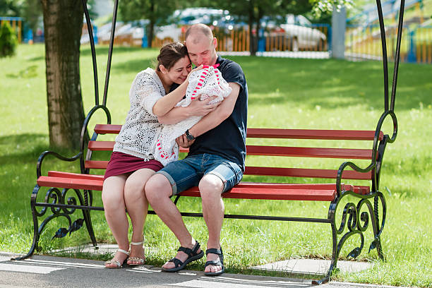 istock Young family sitting on a park bench. 545664092