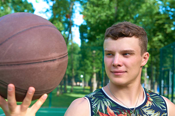 istock Man with basketball ball standing on playground 545665520