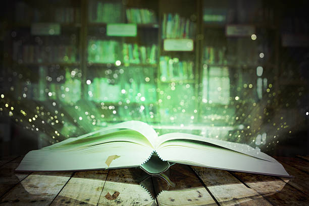istock Image of opened magic book with glister lights. 545667760