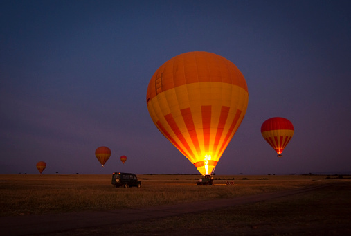 Several hot air balloons illuminated in the darkness awaiting liftoff in New Mexico