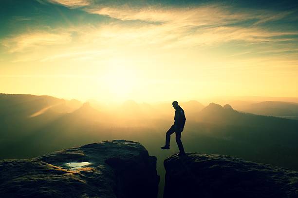 istock Happy man  jumping between rocks, misty mountains. 545675272