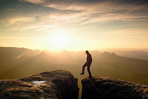 istock Happy man  jumping between rocks, misty mountains. 545675316