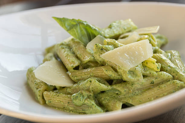 Spring penne with spinach pesto and green pea Spring penne with spinach pesto and green pea rigatoni stock pictures, royalty-free photos & images