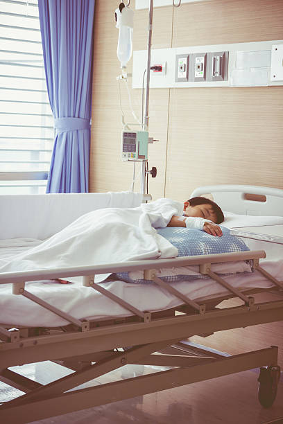 istock Asian boy lying on sickbed with saline intravenous (IV). Health 545676970