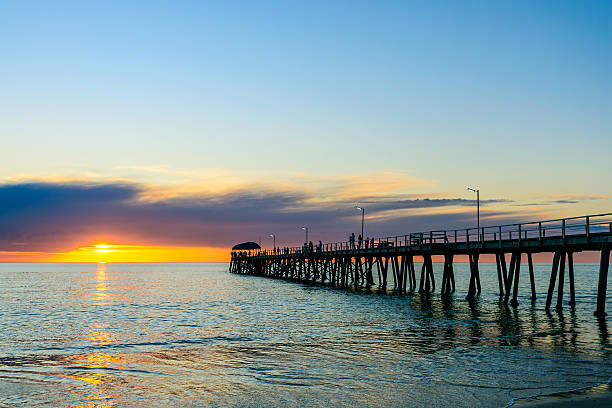 istock People wailking along jetty at sunset 545677524