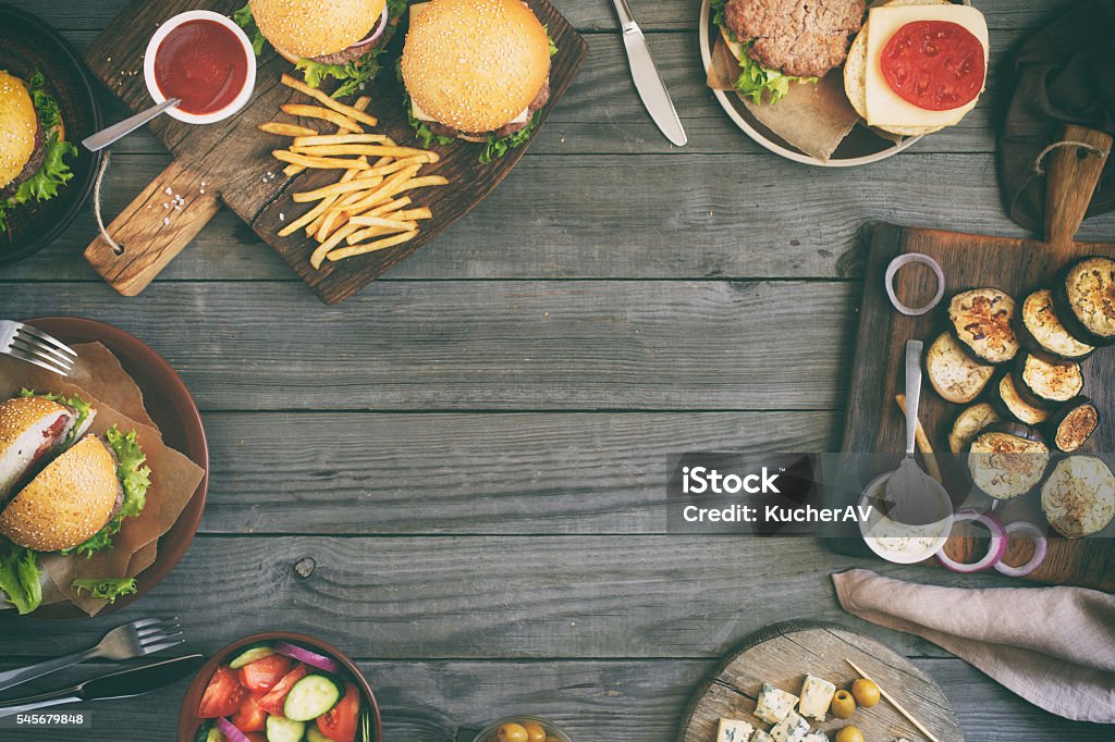 Frame from different burgers with grilled vegetables Frame from various food, burgers, salad, roquefort cheese and vegetables cooked on the grill, top view. Outdoors food Concept Table Stock Photo