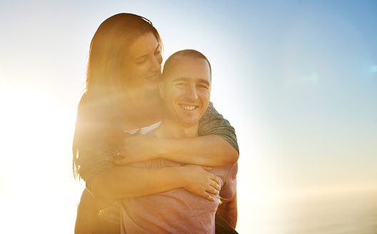 Portrait of a smiling young couple enjoying the day together outside by the ocean