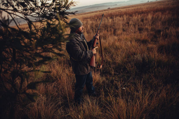 istock Man with rifle and cartridge observing wild animals 545774478