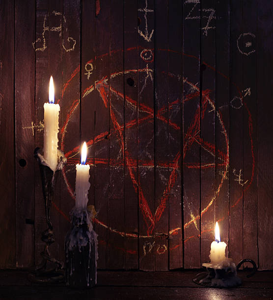 Three burning candles and wooden planks with pentagram stock photo
