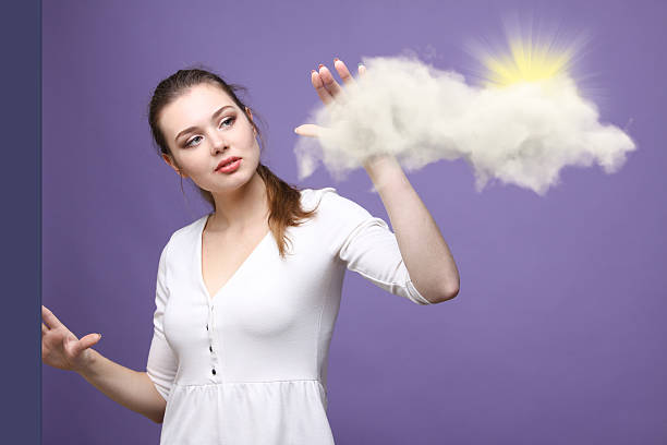 istock Young woman and sun shining out from behind the clouds 545778962