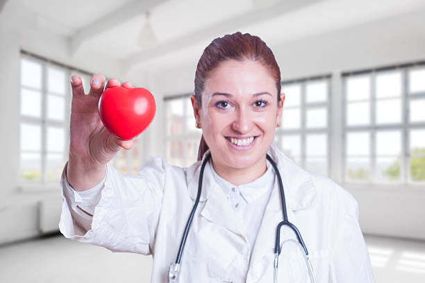 istock Young woman doctor holding a red heart 545779062