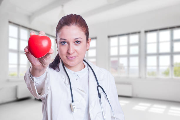 istock Young woman doctor holding a red heart 545779218