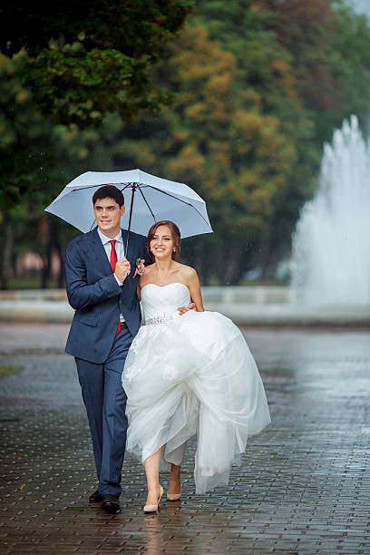 istock Happy Bride and groom at wedding walk white umbrella 545779406